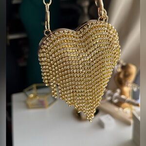 Beautiful heart-shaped clutch bag with an elegant and shiny design.